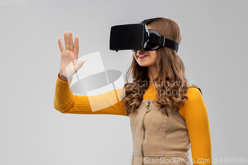 Image of teenage girl in vr glasses over grey background