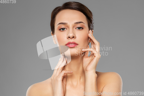 Image of beautiful young woman touching her face