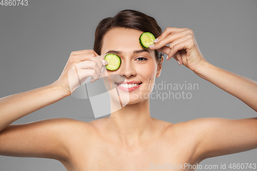 Image of beautiful woman making eye mask of cucumbers