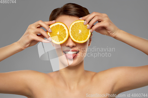 Image of beautiful woman making eye mask of orange slices