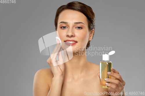 Image of young woman with toner or cleanser and cotton pad