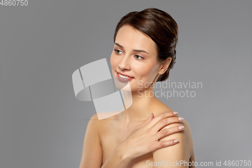 Image of beautiful young woman touching bare shoulder
