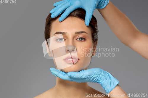 Image of beautiful young woman face and hand in gloves
