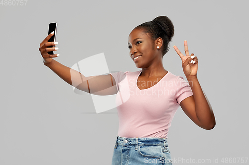 Image of african american woman taking selfie by smartphone