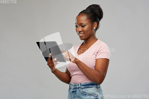 Image of happy african american woman using tablet pc