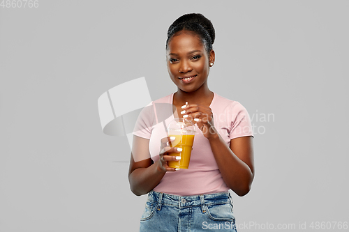 Image of happy african american woman drinking orange juice