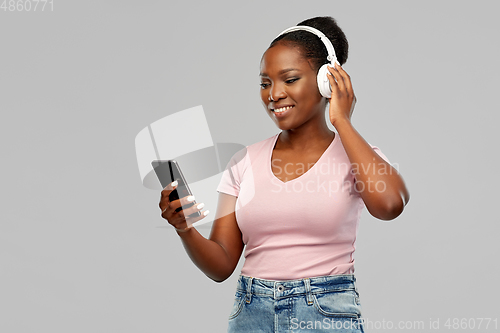 Image of african woman in headphones listening to music