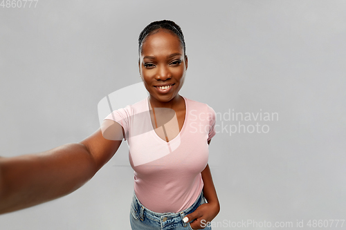 Image of happy african american woman taking selfie