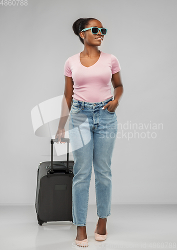 Image of happy african woman in sunglasses with travel bag