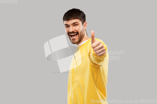 Image of smiling young man showing thumbs up