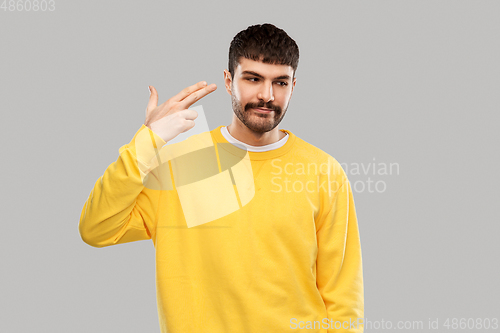 Image of bored man making finger gun gesture