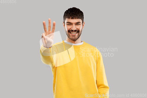 Image of man in yellow sweatshirt showing three fingers