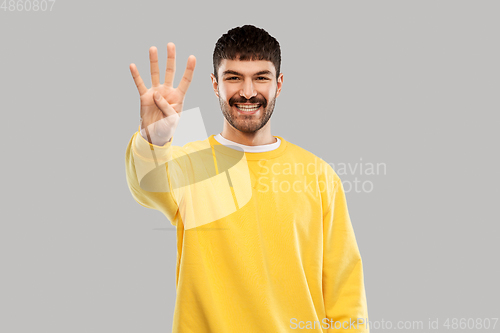 Image of man in yellow sweatshirt showing three fingers