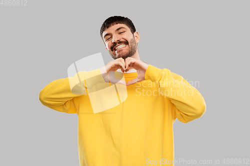 Image of smiling young man in yellow sweatshirt