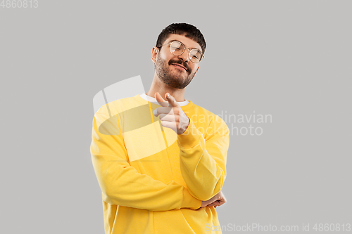 Image of man in yellow sweatshirt pointing finger to camera