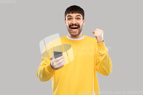 Image of happy smiling young man with smartphone