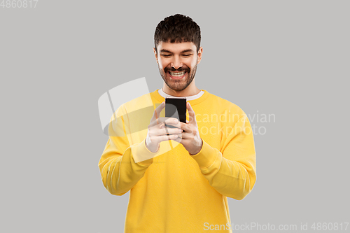 Image of happy smiling young man with smartphone