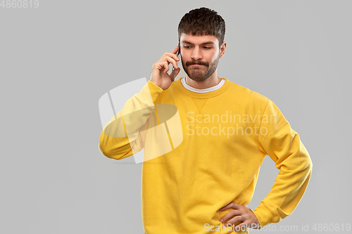 Image of puzzled young man calling on smartphone