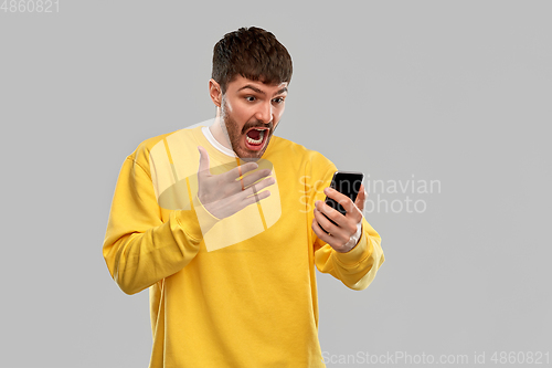 Image of angry young man with smartphone