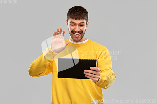 Image of smiling young man with tablet pc having video call