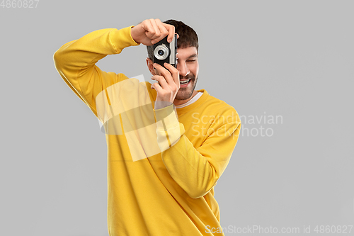 Image of happy smiling young man with vintage film camera