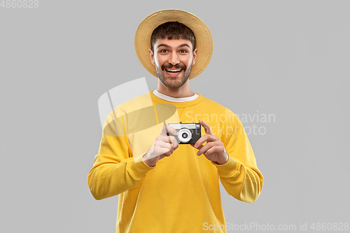 Image of happy man in straw hat with vintage film camera