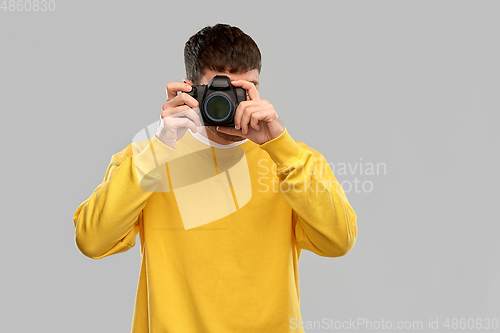 Image of young man with digital camera