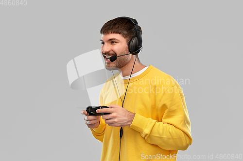 Image of man with headset and gamepad playing video game