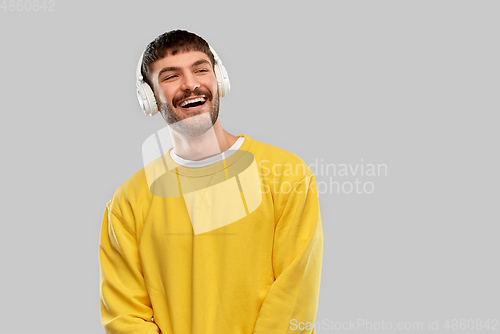Image of happy young man in headphones listening to music