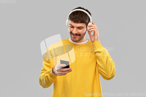 Image of smiling young man with headphones and smartphone
