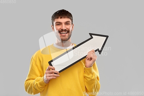 Image of smiling man holding big arrow pointing to right