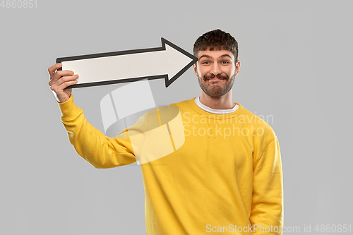 Image of smiling man holding big arrow pointing to his head