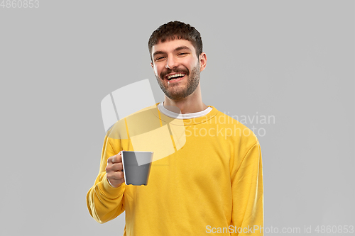 Image of happy smiling young man with coffee cup