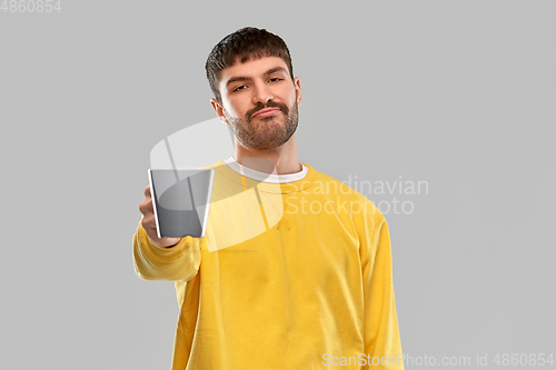 Image of displeased young man with coffee cup