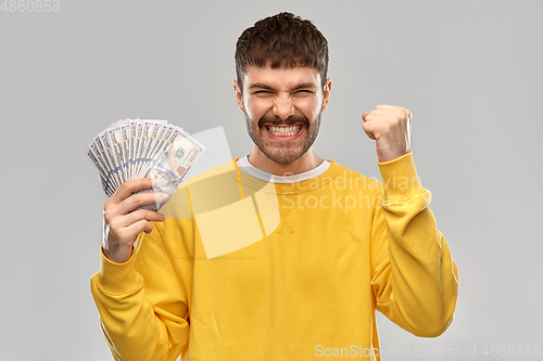 Image of happy young man with money celebrating success