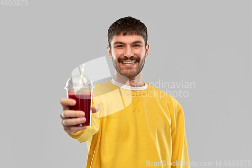 Image of happy man with tomato juice in takeaway cup