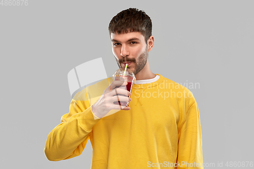 Image of happy man with tomato juice in takeaway cup