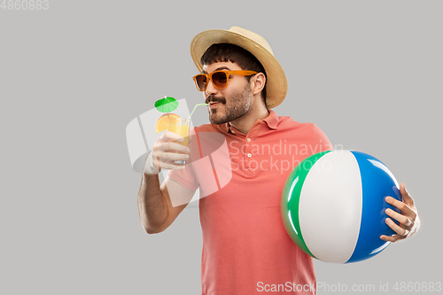 Image of happy man with orange juice and beach ball