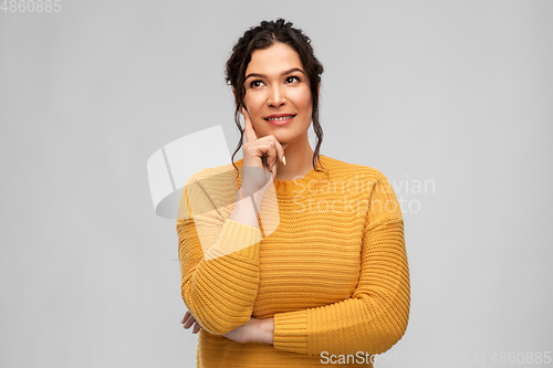 Image of thinking smiling young woman with pierced nose