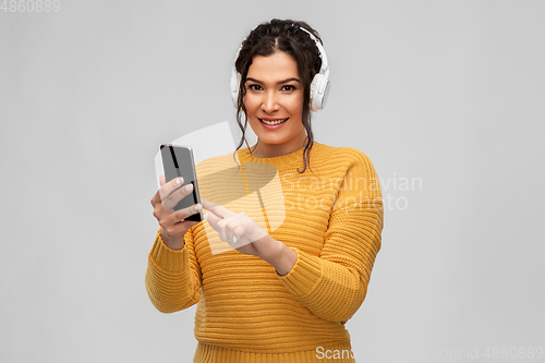 Image of woman in headphones with smartphone