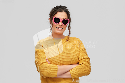 Image of smiling young woman in heart-shaped sunglasses