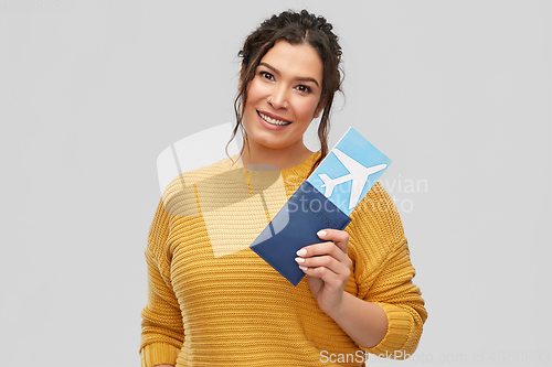 Image of happy young woman with air ticket and passport