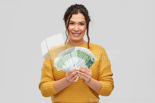 Image of happy smiling young woman with euro money