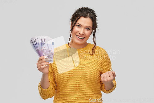 Image of happy smiling young woman with euro money