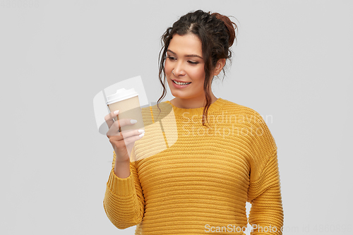 Image of smiling woman with pierced nose holding coffee cup