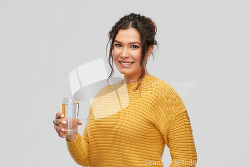 Image of smiling young woman with water in glass