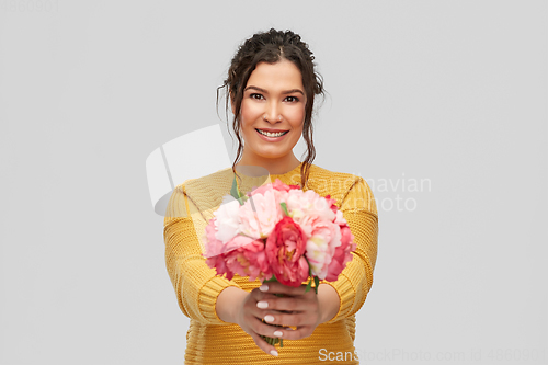 Image of happy smiling young woman with bunch of flowers