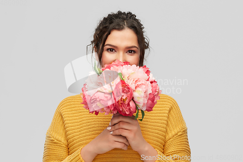 Image of happy smiling young woman with bunch of flowers