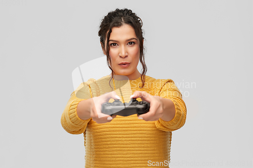 Image of happy young woman with gamepad playing video game