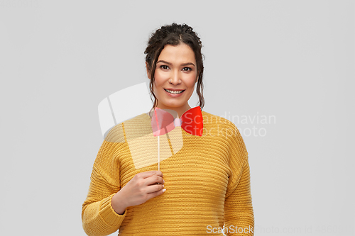 Image of happy young woman with big red bowtie party prop